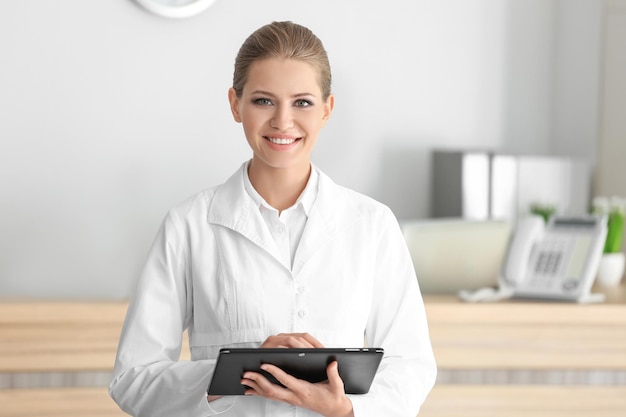 Young female receptionist holding tablet computer in hospital