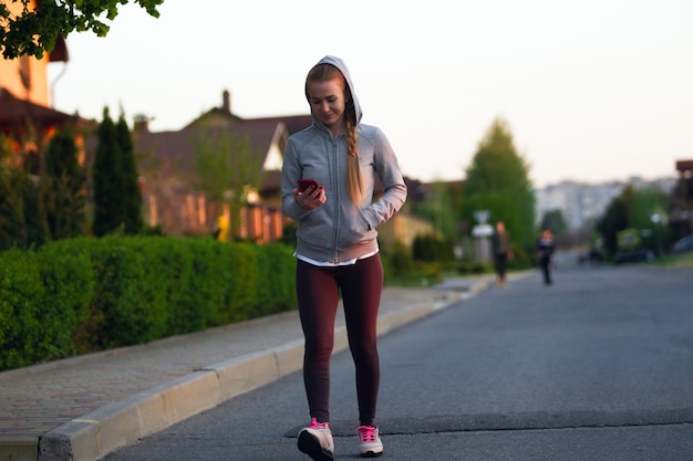 Young female runner, athlete during jogging in the city street in sunshine.