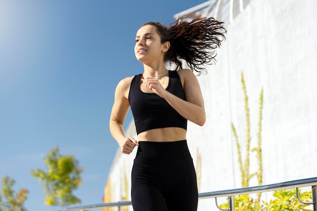 Young female runner jogging on summer street