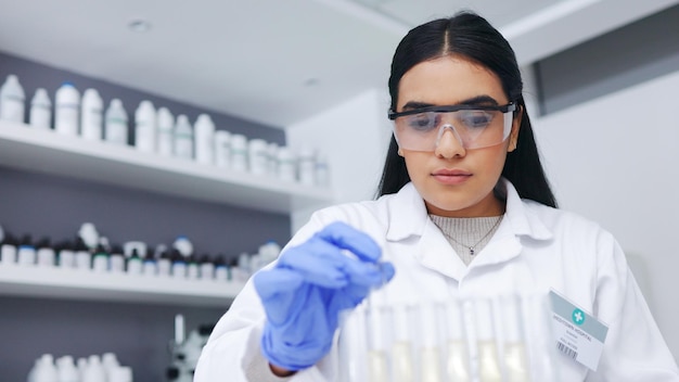 Young female scientists doing tube testing in a modern laboratory Micro biologist examine liquid bacteria in glassware mixture to invent a vaccine cure for virus at innovative research hospital