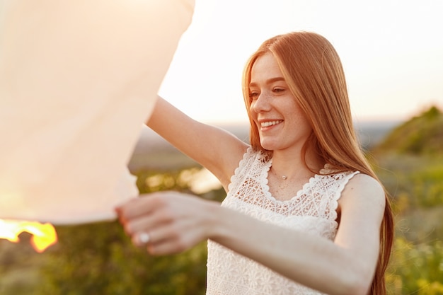 Young female smiling and launching sky lantern