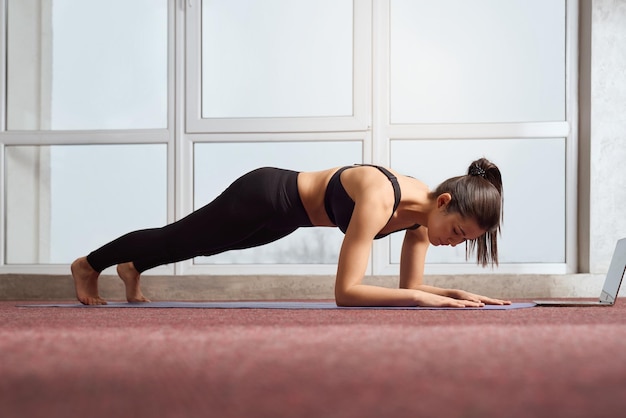 Young female standing in plank