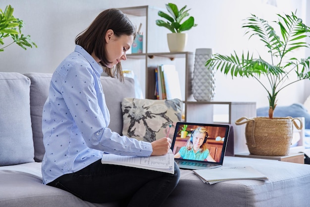 Young female teacher making video conference for child girl sitting in home