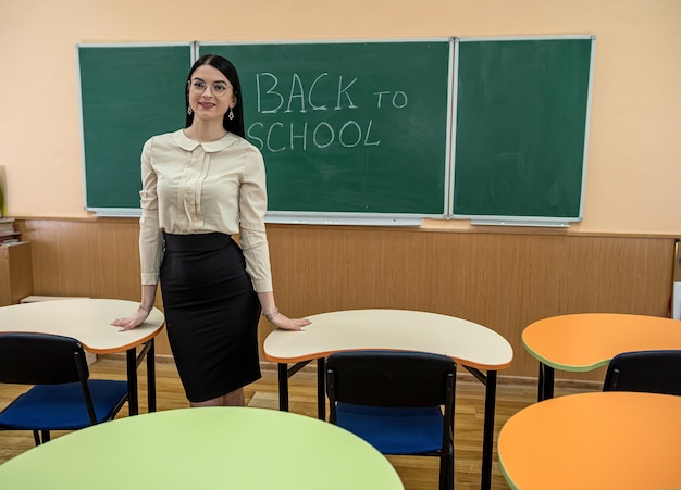 Young female teacher near blackboard and start study