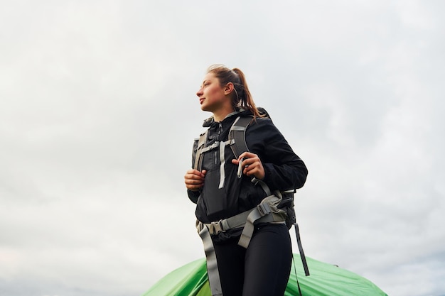 Young female traveler in sportive clothes having a walk outdoors