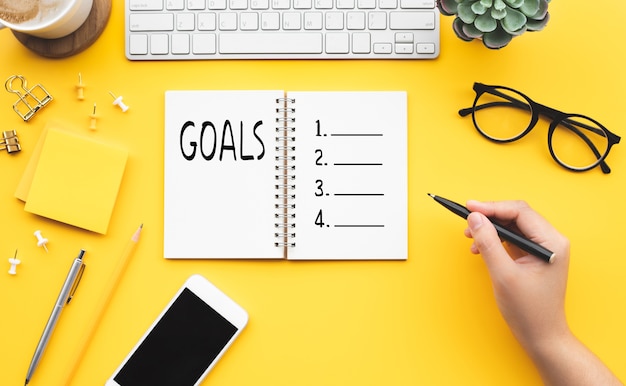 Young female writing checklist on a notebook