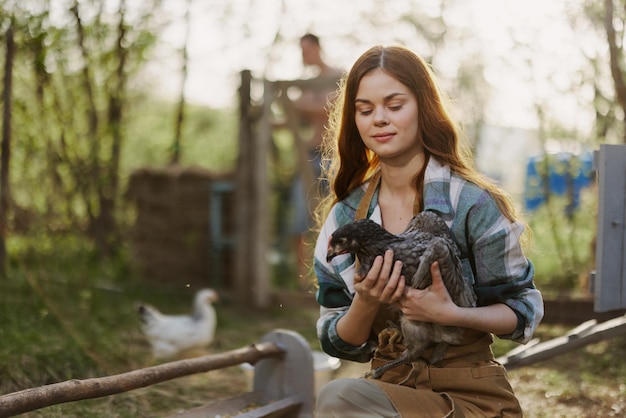 Photo young female zoologist examines chicken for diseases on the farm high quality photo