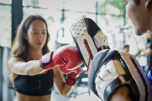 Young fit lady training with boxing gloves