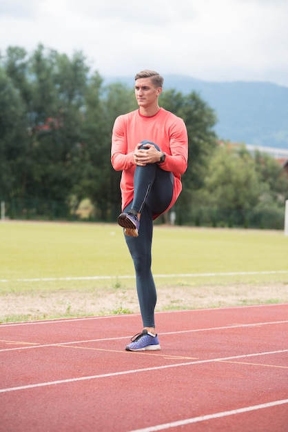 Young Fitness Man Runner Stretching Legs Before Run