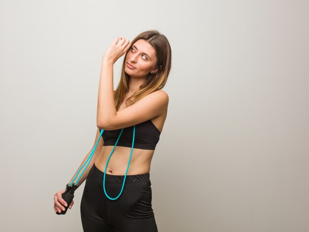 Young fitness russian woman making the gesture of a spyglass