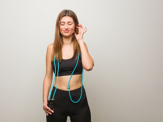 Young fitness woman covering ears with hands