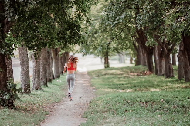 Young fitness woman running around in the park.