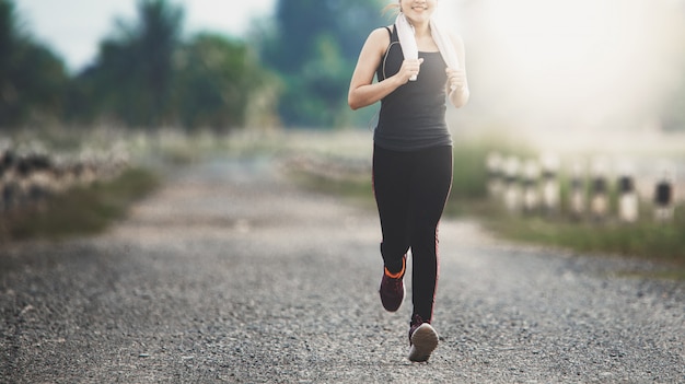 Young fitness woman running on the road in the morning.