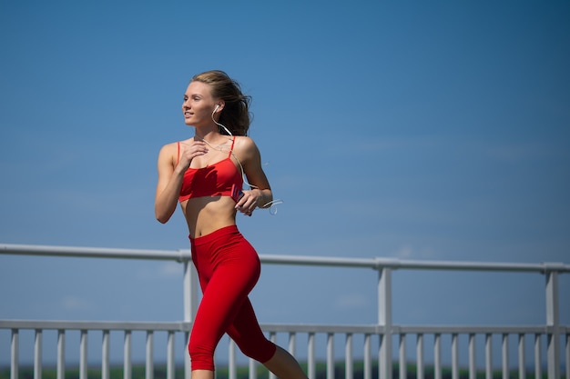 Young fitness woman running on sky backround, The concept of a healthy lifestyle