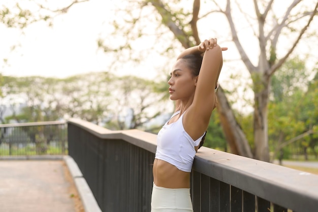 A young fitness woman in sportswear exercising in city park Healthy and Lifestyles