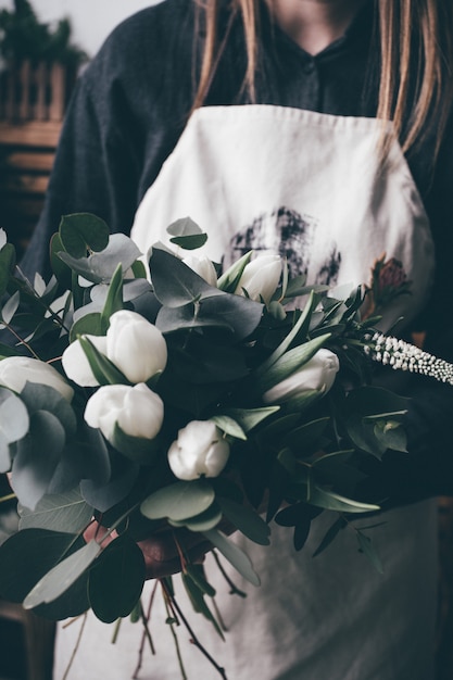 Young florist woman making beauty bouquet