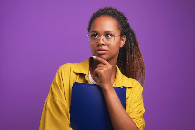 Young focused african american woman wearing glasses holding plastic folder