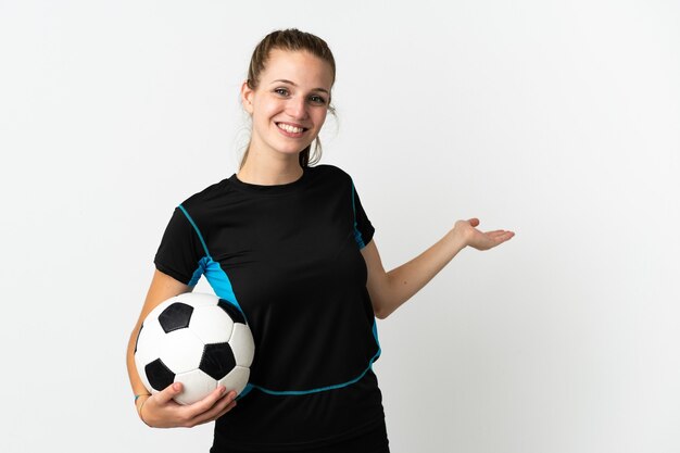 Young football player woman isolated on white background extending hands to the side for inviting to come