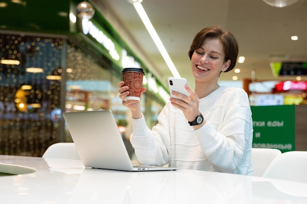 Young freelancer working on laptop from cafe