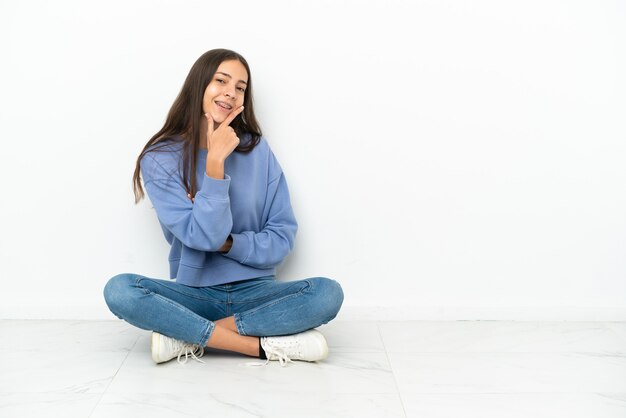 Young French girl sitting on the floor smiling