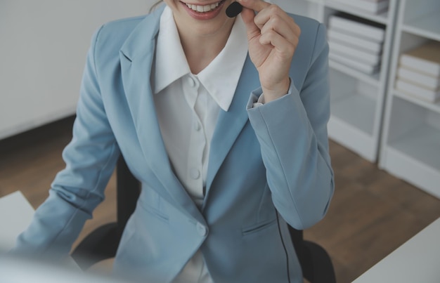 Young friendly operator woman agent with headsets working in a call centre