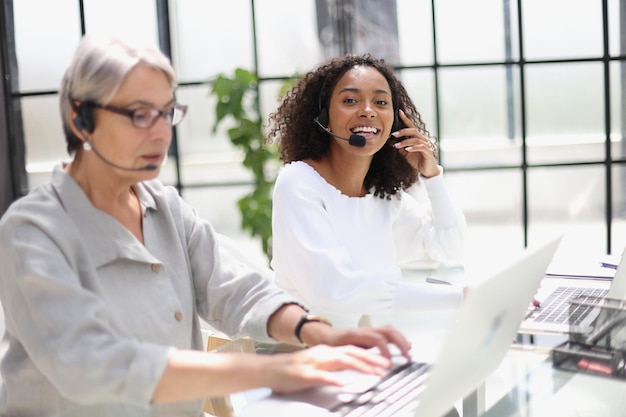 Young friendly operator woman agent with headsets working in a call centre