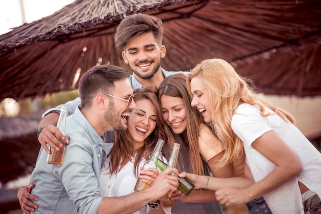 Young friends drinking beer and having fun outdoors