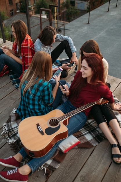 Young friends looking at their smartphones. Social media addiction. Modern teenage problems. Need of sharing