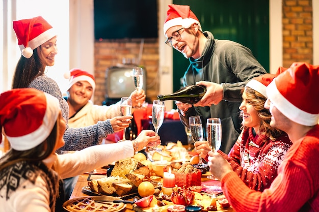 Young friends on santa hats celebrating Christmas together