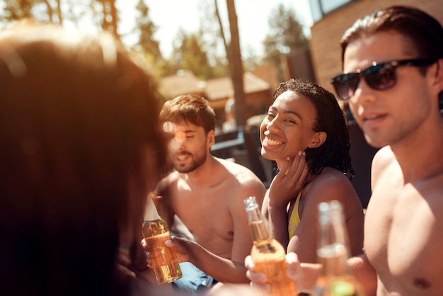 Young Friends with Alcoholic Drinks in Pool.