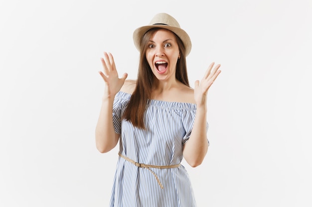 Young fun overjoyed woman in blue dress, hat keeping mouth wide open, looking surprised, posing isolated on white background. People, sincere emotions, lifestyle concept. Advertising area. Copy space.