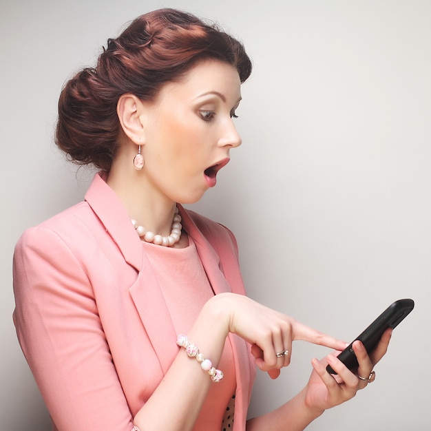 Young funny businesswoman with mobile