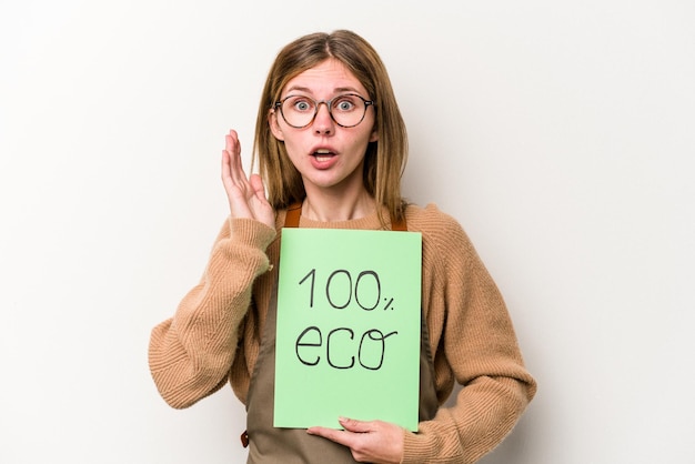 Photo young gardener woman holding a 100 eco placard isolated on white background surprised and shocked