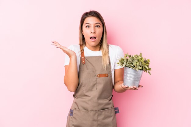 Young gardener woman surprised and shocked