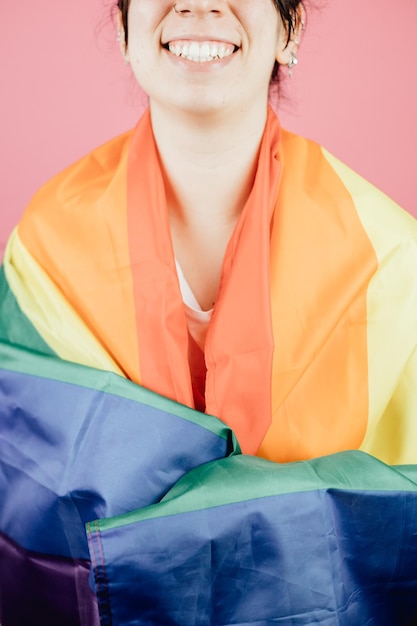 Young gay man waving a a rainbow pride flag over his shoulder in the middle of the street. Concept of The LGBT community, minority rights, protection of human rights. Copy space,Madrid city