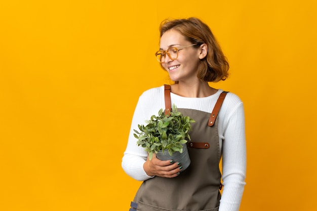 Young Georgian woman holding a plant isolated