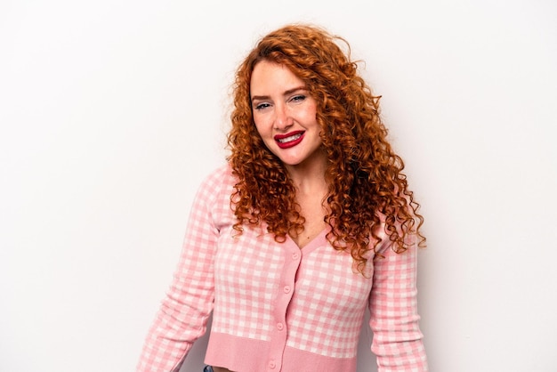 Young ginger caucasian woman isolated on white background laughs and closes eyes feels relaxed and happy