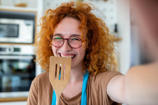 Young ginger woman food blogger taking a selfie with a welder