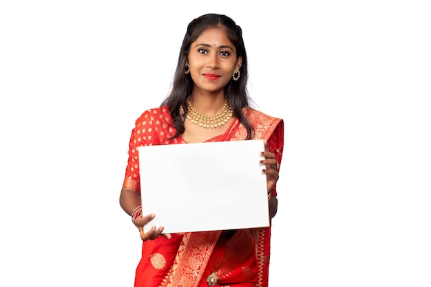 A young girl or businesswoman wearing a saree and holding a signboard in her hands on a white background