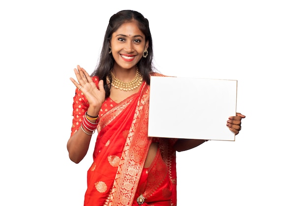 A young girl or businesswoman wearing a saree and holding a signboard in her hands on a white background