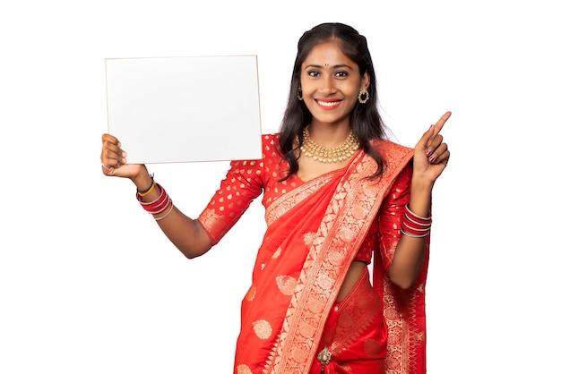 A young girl or businesswoman wearing a saree and holding a signboard in her hands on a white background