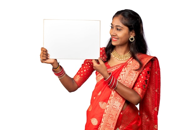 A young girl or businesswoman wearing a saree and holding a signboard in her hands on a white background