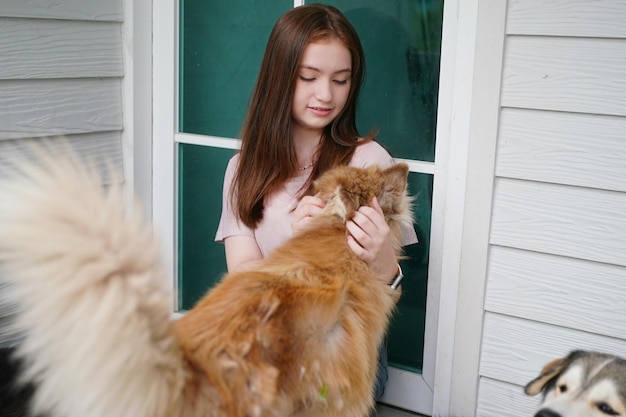 Young girl in casual clothes hugging golden retriever while sitting on floor