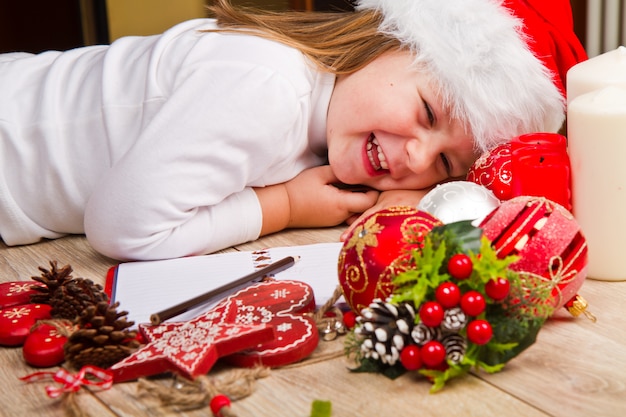 Young girl in christmas hat write letter to Santa Claus