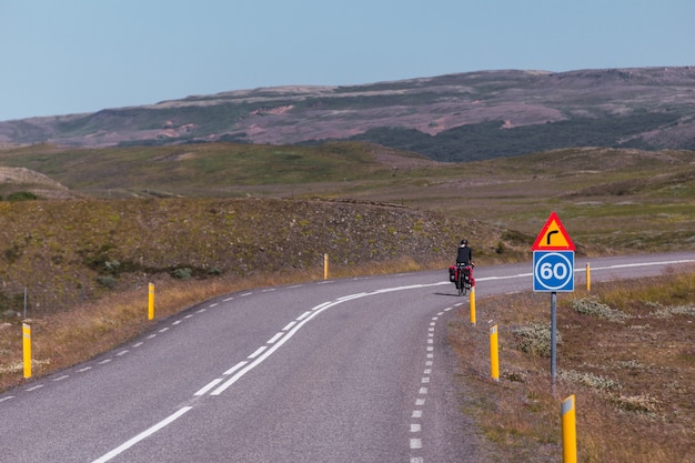 Young girl cycling on a paved road in Iceland.