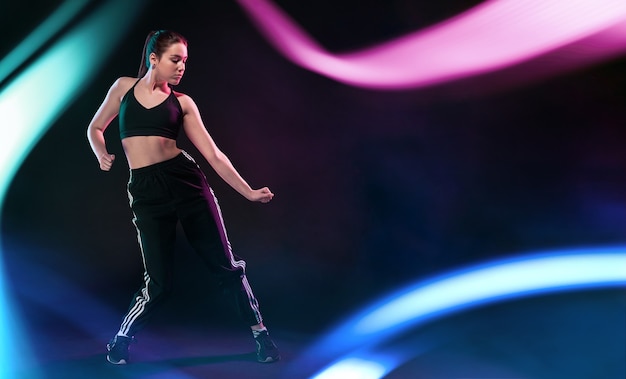 Young girl dancing in floating neon lights