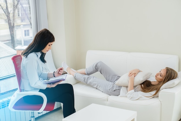 A young girl during depression communicates with a psychologist in the office. Psychological help.