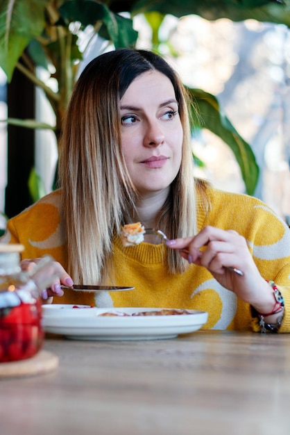 A young girl eats in a cafe, life style.