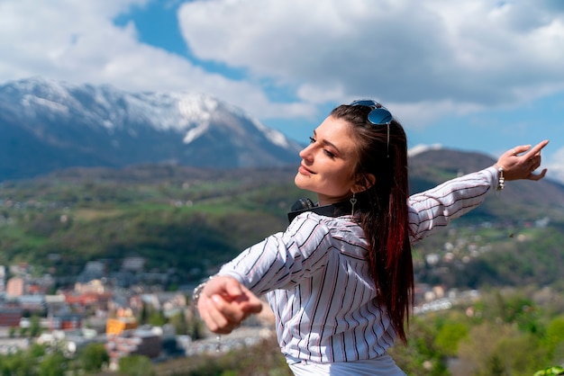 Young girl enjoying visiting a city with her arms open in the air