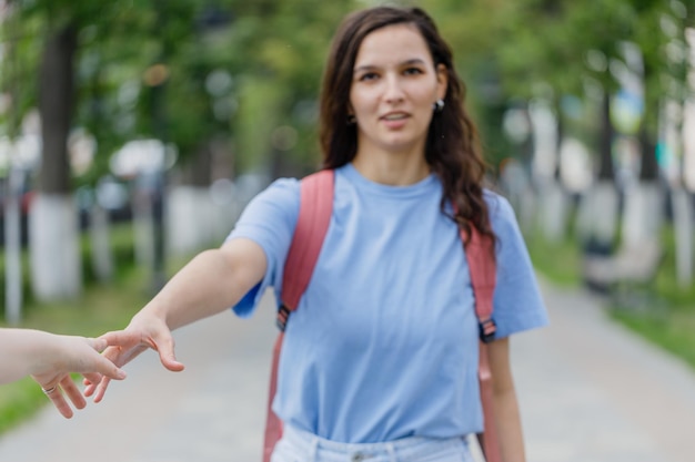 Young girl extends her hand to a meeting and offers friendship